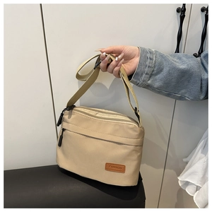 Détail du sac bandoulière en nylon kaki avec plusieurs compartiments et sangle réglable