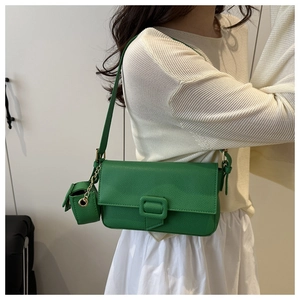 Close-up of bright green baguette bag in lychee leather with matching mini charm pendant