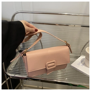 Close-up of pink litchi grain texture on the rectangular flap of a trendy baguette bag