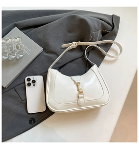 Dettaglio della borsa hobo bianca con chiusura in metallo dorato e trama in pelle