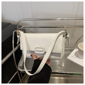 Close-up of white baguette bag showing high-quality lychee grain leather and shoulder strap