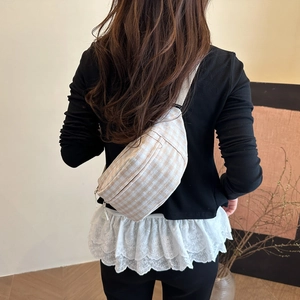 Beige karierte Umhängetasche für Damen im sommerlichen Freizeit-Stil am Model getragen
