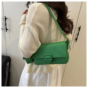 Close-up of grass green baguette bag with litchi texture and matching square buckle