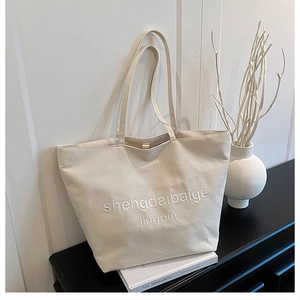 Détail de la broderie 3D blanche sur un grand sac cabas en toile au style minimaliste