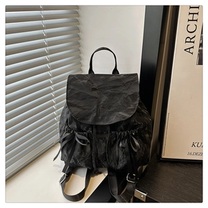 Détail du sac à dos noir avec nœuds élégants en ruban et broderie Nika raffinée