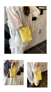 Detailed views of yellow lychee pattern tote bag with smile pendant and shoulder strap