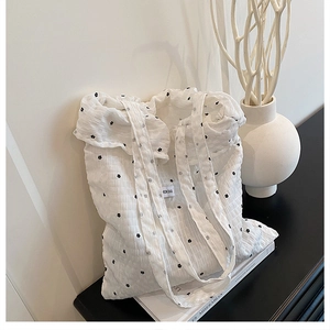 Close-up of white floral tote bag with pleated texture and Fashion Bag label details