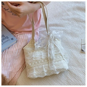 Close-up detail of beige lace tote bag featuring 3D floral crochet and layered ruffles