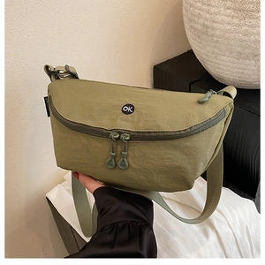 Close-up of olive green nylon bag with OK embroidery and durable dual zippers