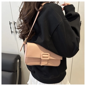Detail of pink lychee grain leather shoulder bag with decorative buckle on a model