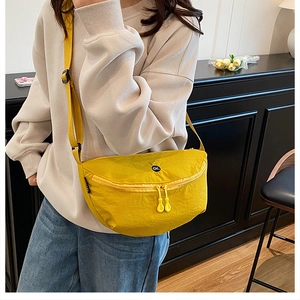 Detail of yellow nylon crescent crossbody bag featuring adjustable strap and OK logo