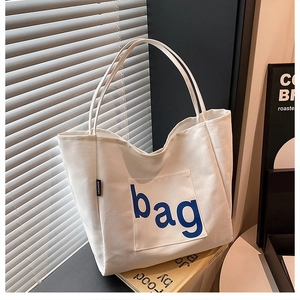 White canvas tote bag with blue 'bag' print, spacious shoulder bag for daily use