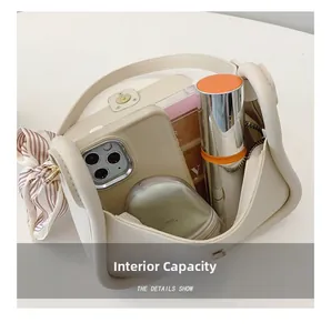 Internal capacity of beige small square bag showing phone and cosmetics space