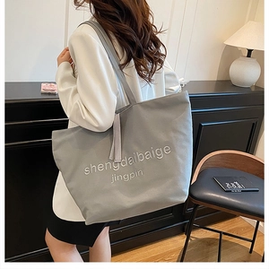 Detailed view of the large capacity grey canvas tote bag with elegant embroidery