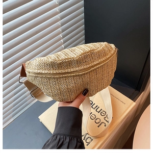 Close-up of beige woven straw chest bag with metal zipper and adjustable strap