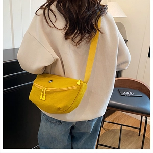 Adjustable crossbody strap on bright yellow crescent saddle bag for women with dual zippers