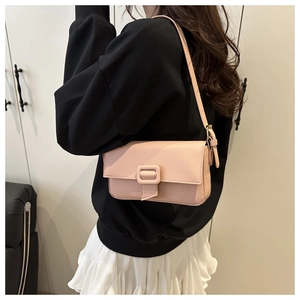 Pink leather baguette shoulder bag shown on model for a stylish casual look