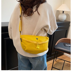 Rear view of model wearing a bright yellow nylon crescent crossbody bag with OK patch