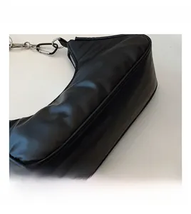 Close-up of the smooth black pleated leather surface and silver zipper of this crescent bag