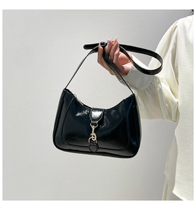 Dettaglio di una borsa hobo in vernice nera lucida con fibbia in metallo dorato