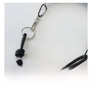 Detail view of black leather shoulder strap with silver ring and metallic bead accents