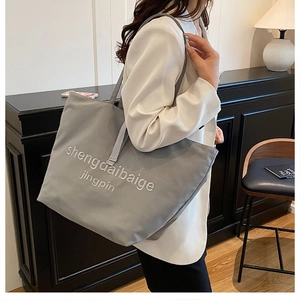 Détail du cabas en toile grise avec tissu haute densité et broderie blanche