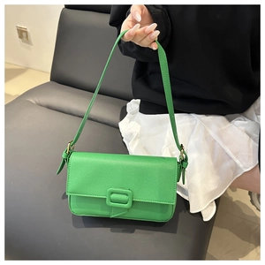 Detail of green lychee leather baguette bag with matching large square buckle accent