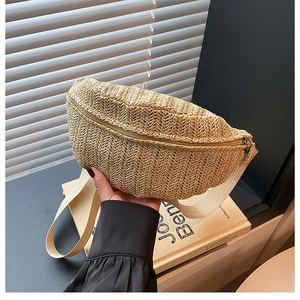 Detail of woven straw chest bag showing natural beige wave texture and sturdy top zipper