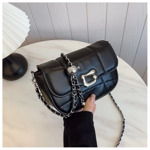 Détail du sac à bandoulière matelassé noir avec chaîne argentée et fermoir design