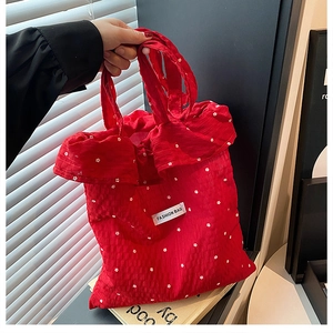 Detail of red floral crinkle tote bag with FASHION BAG label and textured fabric