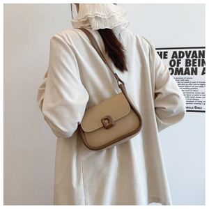 French retro style crossbody bag with color-block leather shown on shoulder with poster