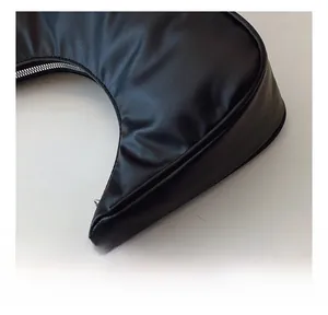 Close-up of fine stitching and metal zipper on black crescent leather shoulder bag