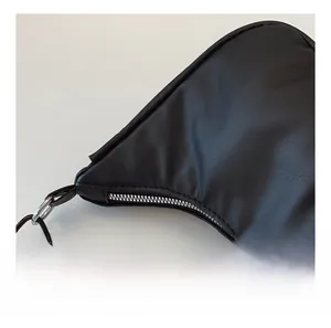 Detail shot of smooth silver zipper and textured black PU leather on crescent bag