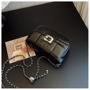 Détail d'un sac bandoulière en cuir matelassé noir avec fermoir métallique argenté