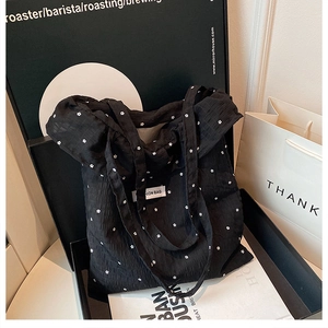 Detailed macro view of black floral tote bag with branded Fashion Bag label