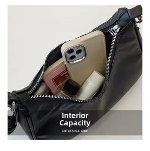 Top view detail of a black chain bag showing large capacity for phone and cosmetics