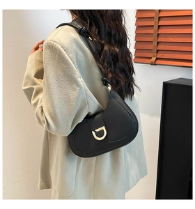 Detail of black half-moon bag featuring golden D-buckle and elegant knotted shoulder strap