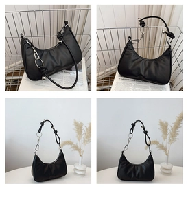 Detail view of a black crescent hobo bag with silver chain and unique knot shoulder strap