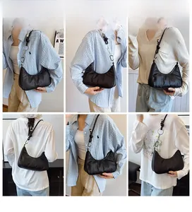Detail view of black crescent hobo bag featuring knotted shoulder strap and silver hardware