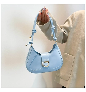 Détail du sac hobo bleu ciel avec finition brillante et fermoir en métal doré élégant