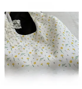 Close-up of floral fabric bag with yellow daisy print and white lace bow detail