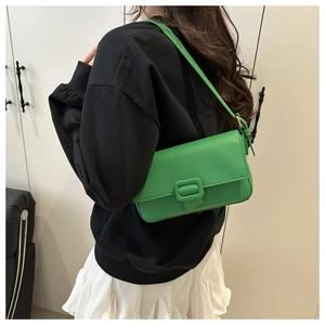 Detail of bright green baguette bag showing lychee pattern leather and square buckle