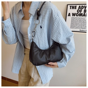 Close-up of black crescent hobo bag with silver ring hardware and metal carabiner detail