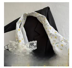 Detail of white floral canvas tote featuring yellow daisies and a lace bow accent