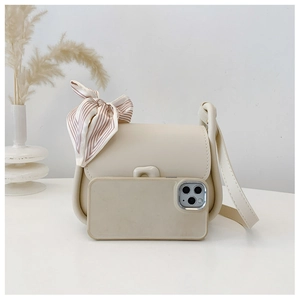 Mini cream leather shoulder bag with a striped bow tie and smartphone for size reference
