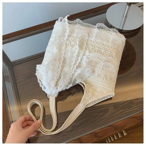 Detailed close-up of white lace beach tote bag with layered ruffles and smooth faux leather strap