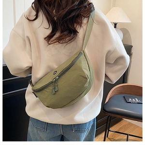 Detailed back view of a green nylon crescent crossbody bag with OK patch and dual zippers