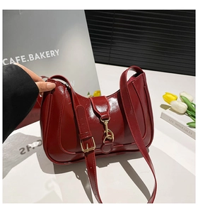 Dettaglio della borsa hobo bordeaux con finitura lucida e chiusura a pistone dorata