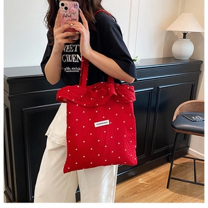 Détail du sac cabas plissé rouge à pois avec bords volantés et étiquette mode