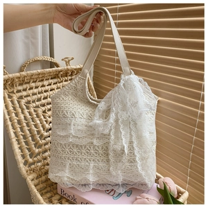Detail of elegant beige lace tote bag with a large bow and premium faux leather handles